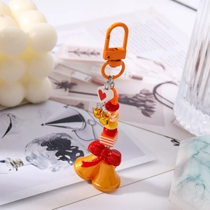 Détail d'un porte-clés de Noël perlé avec nœud rouge et clochettes dorées