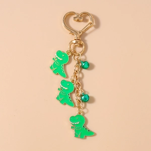 Detail of green dinosaur keychains with heart clasp and matching green bells