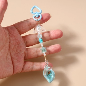 Detail of blue ocean theme keychain with heart clasp, sea shell charm, and star beads