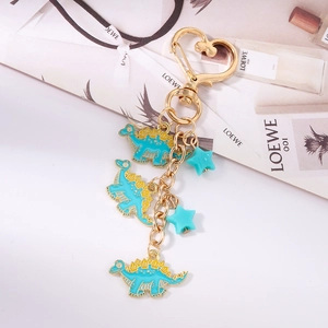 Detail view of blue dinosaur charms and gold heart carabiner on a stylish keychain