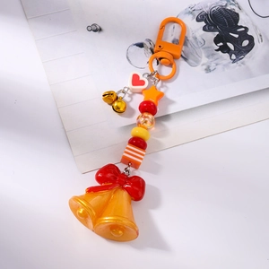Détail d'un porte-clés festif avec grandes cloches orange et perles colorées de Noël