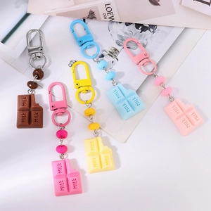 Detail view of five colorful resin chocolate milk charms with metallic keychains and beads