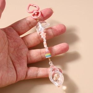 Detailed view of handmade ocean keychain with resin seashell, pink star, and pearl beads