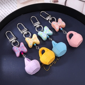 Detailed macro view of colorful macaron-style bow and woven basket keychain charms