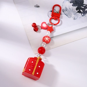Détail d'un porte-clés de Noël perlé avec pendentif boîte cadeau rouge et breloques