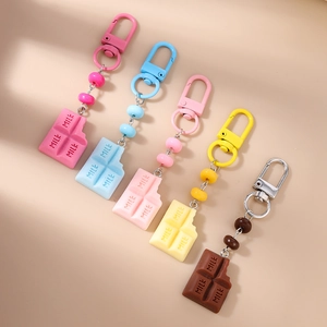 Close-up of five colorful chocolate bar keychains with MILK engraving and D-ring clasps