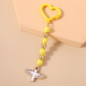 Detail of beaded keychain with yellow heart clasp and white winged cross pendant charm
