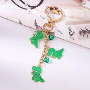 Detail of cute green dinosaur charms and heart-shaped golden clasp keychain