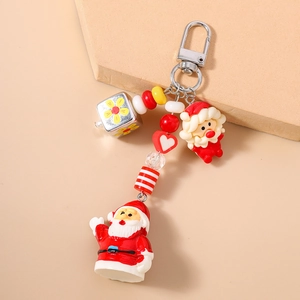Détail d'un porte-clés de Noël perlé avec figurines du Père Noël et accents rouges