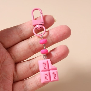 Macro shot of pink chocolate keychain with MILK text and metal D-ring buckle