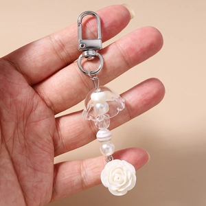 Porte-clés artisanal perlé avec pendentif rose blanche et détails de perles rayées