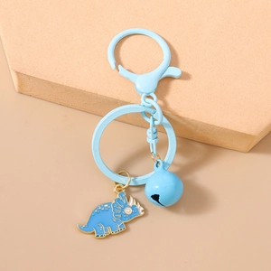 Detail of light blue enamel triceratops keychain with matching bell and golden metal edges