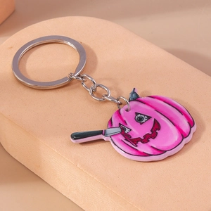 Detail of pink Halloween pumpkin keychain with bloody knife eye and silver metal chain