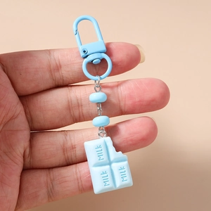 Macro detail of a creative light blue milk chocolate keychain with round beads