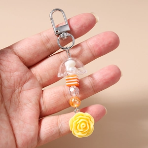 Gros plan d'un porte-clés en forme de méduse avec perles rayées orange et fleur de rose