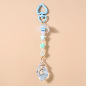 Detail of blue heart-shaped clasp and transparent conch pendant on a beaded keychain