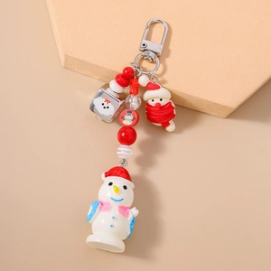 Détail d'un porte-clés bonhomme de neige de Noël perlé avec bonnet rouge sur fond beige