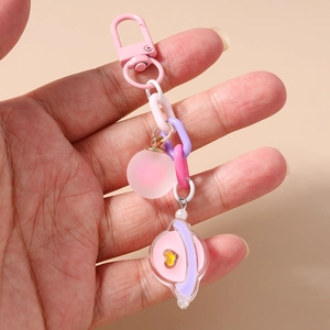 Gros plan du porte-clés planète rose avec chaîne colorée et breloque en perles