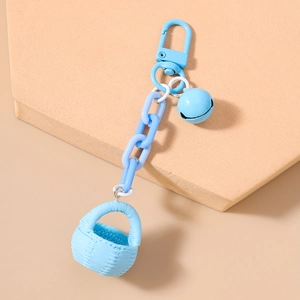 Détail d'un porte-clés panier tressé bleu clair avec petite clochette et fermoir solide