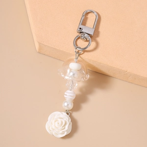 Détail d'un porte-clés rose avec perles blanches et ornements de perles à rayures
