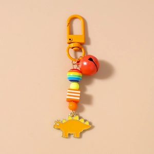 Detail of vibrant orange stegosaurus keychain with red bell and colorful beads charm
