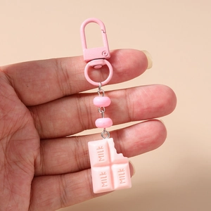 Detailed close-up of a pink realistic chocolate keychain with milk text and pink metal clasp