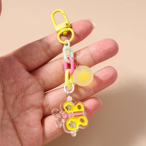 Détail d'un porte-clés papillon coloré avec chaîne épaisse et pendentif boule givrée