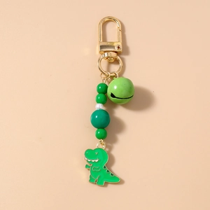Detail of cute green dinosaur charm with beads, bell and golden lobster clasp