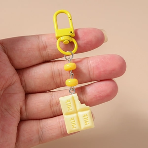 Close-up of a creative chocolate food pendant with Milk lettering and yellow metal buckle