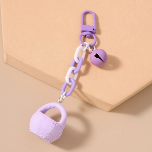 Détail du charme de panier tressé violet avec chaîne épaisse et cloche en métal mat