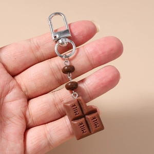 Detailed close-up of realistic chocolate bar keychain with milk lettering and coffee beads