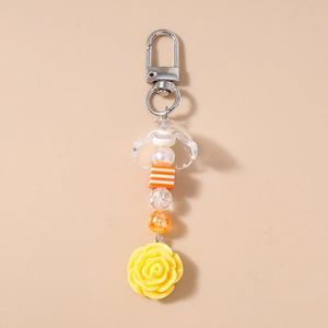 Détail du porte-clés rose jaune avec perles rayées et fermoir mousqueton en argent