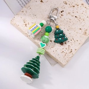 Détail d'un porte-clés sapin de Noël avec perles en résine colorées sur texture pierre