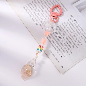 Close-up of pink heart clasp with a transparent conch pendant filled with real sand and shells
