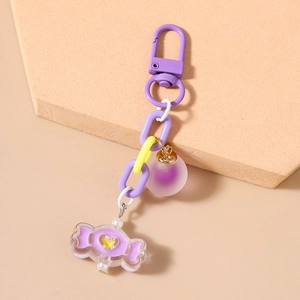 Détail d'un porte-clés violet à grosse chaîne avec pendentif de bonbon en forme de cœur