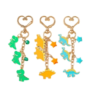 Three colorful dinosaur keychains with heart hooks and star charms on white background