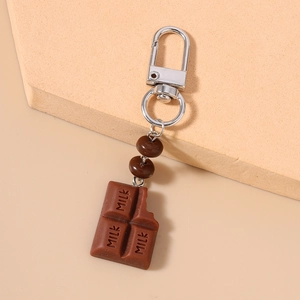 Macro detail of realistic chocolate bar keychain featuring MILK engraving and silver D-ring