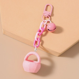 Vue détaillée d'un porte-clés panier tressé rose avec clochette et chaîne en plastique