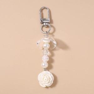 Gros plan détaillé d'un pendentif rose blanche avec perles élégantes en acrylique