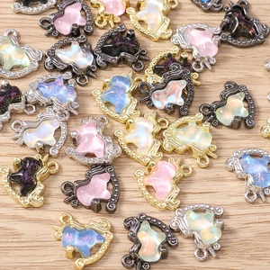 Detailed view of colorful unicorn charms for jewelry making on light wood background