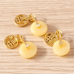 Trois pendentifs en jade rétro chinois avec breloque dorée Fu sur fond de bois