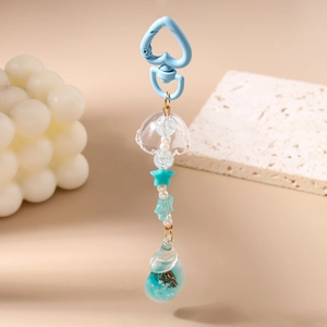 Detailed close-up of an ocean-themed keychain with blue sea shell pendant and star beads