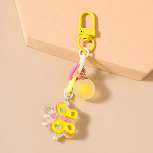 Détail macro du pendentif papillon en acrylique et chaîne macaron sur un porte-clés élégant