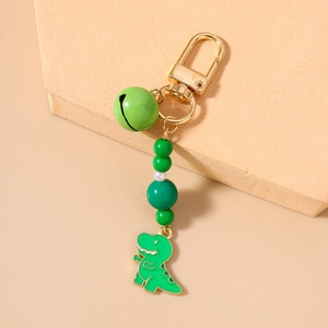 Detail of green dinosaur keychain with beads, bell, and gold-tone spring clasp