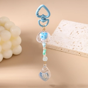 Detail of blue heart clasp and jellyfish ocean keychain with shells and star beads