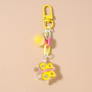 Détail d'un porte-clés papillon jaune avec chaîne colorée épaisse et breloque ronde