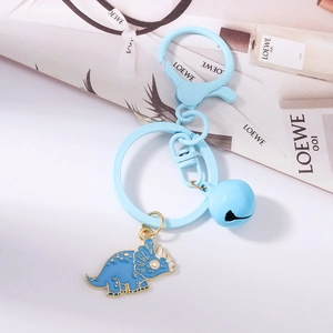 Detail of light blue enamel triceratops keychain with matching ring and small bell