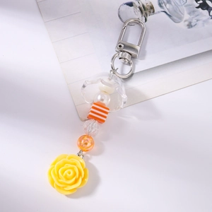 Détail de la rose jaune en résine et des perles rayées sur le porte-clés floral