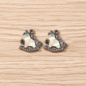 Detail of unicorn rocking horse charms with gun-black metal and iridescent opal inlay