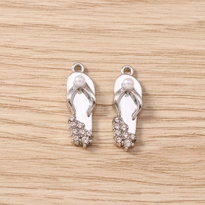 Makro-Detail von silbernen Flip-Flop-Anhängern mit Strass und Perlen für DIY-Schmuck